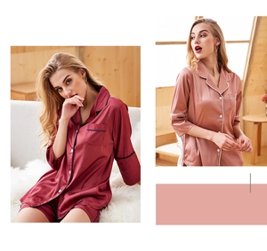 Close-up of silk pajama set featuring button-down shirt and shorts in burgundy and pink
