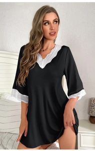 Detail of V-neck lace trim and modal fabric texture on a loose black sleepshirt