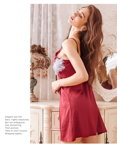 Détail d'une nuisette en satin rouge avec de la dentelle délicate sur le décolleté