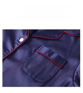 Detail of navy blue silk pajama set featuring red piping and white button accents