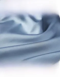Detail shot of smooth blue ice silk fabric showing glossy texture and elegant drape
