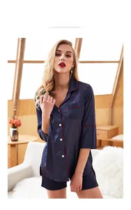 Detail of navy blue silk pajamas set with short sleeves and red piping contrast