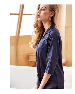 Detail view of navy blue satin pajama top with red piping and classic lapel collar