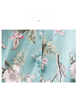 Detail aus hellblauem Chiffon-Stoff mit rosa Blumenmustern und Vogelmotiven für Damen