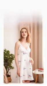 Dettaglio della camicia da notte in raso bianco con gru blu e pizzo delicato sullo scollo