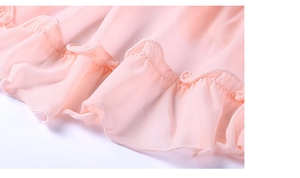 Gros plan sur le tissu en mesh rose transparent avec ourlet à volants et coutures fines