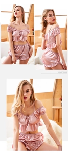 Détail d'un ensemble de pyjama en satin rose avec volants et nœud pour la maison