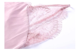 Détail macro du tissu en satin de soie avec dentelle fine sur une nuisette rose