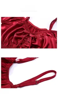Détail du caraco en satin rouge avec nœud au décolleté et fines bretelles réglables