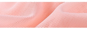 Détail du tissu en maille nid d'abeille rose montrant la texture de la nuisette
