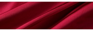 Close-up of deep red silk nightgown fabric with smooth satin texture and elegant drape