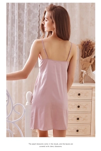 Détail d'une nuisette en satin rose poudré avec fines bretelles et texture de soie lisse