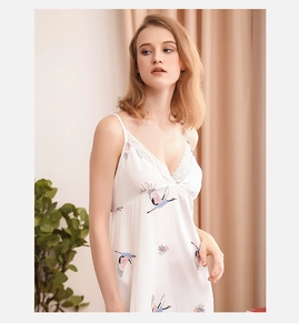 Dettaglio della camicia da notte in raso bianco con stampa di gru e pizzo fine