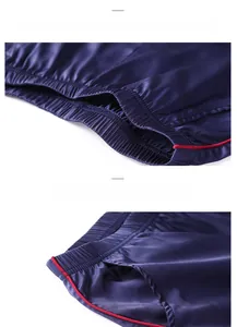 Detail of navy silk pajamas showing elastic waistband and red contrast piping craftsmanship