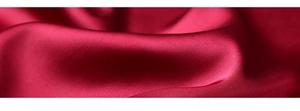 Vue détaillée de la texture du tissu satiné rouge brillant et de la matière en soie