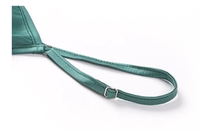 Détail de caraco en satin vert avec fine bretelle et boucle de réglage en métal argenté