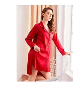 Detail of red silk sleepshirt featuring dark blue piping on the cuffs and curved hemline