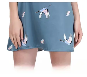 Dettaglio dell'orlo e della stampa di uccelli su camicia da notte in raso blu elegante