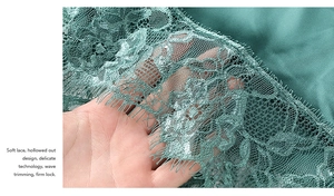 Détail du tissu en dentelle vert foncé avec motifs floraux et texture en maille fine