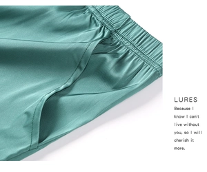 Détail du pantalon de pyjama en satin vert avec taille élastique et poches latérales