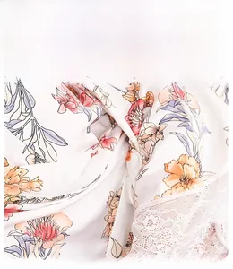 Detailed view of white satin robe with orange floral print and white lace trim edge