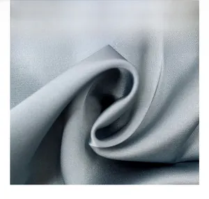 Detailed macro view of the silver blue ice silk satin fabric texture and silky sheen