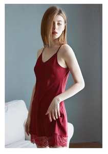 Détail de la nuisette en soie rouge bordeaux avec bordure en dentelle sur l'ourlet