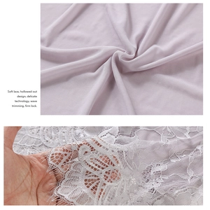Détail du tissu en maille lavande et dentelle florale blanche avec bordure en cils