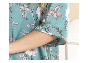 Close-up of light green satin robe featuring delicate floral prints and elegant cuff knot details