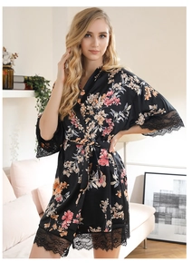 Detailed macro view of the delicate floral print and lace trim on the black silk robe