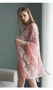Détail du peignoir en dentelle rose clair avec motifs floraux et bords en cils
