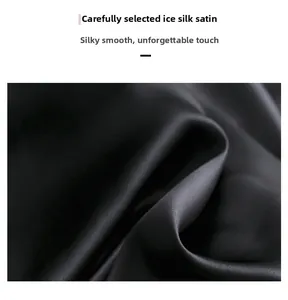 Gros plan du tissu en satin de soie glacée noire montrant texture lisse et éclat doux