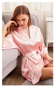 Pale pink satin bridal robe with wide sleeves shown in a cozy home interior setting
