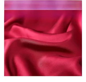 Close-up of smooth burgundy ice silk satin fabric with elegant lace stitching detail