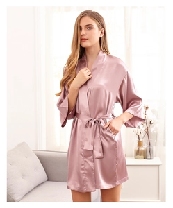 Detail of pink satin bridal robe featuring smooth silk texture and elegant waist tie design