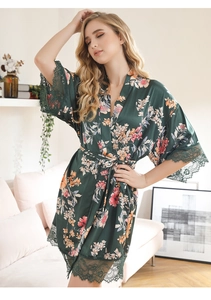 Detail of dark green satin robe with floral print and elegant lace trim on the sleeves