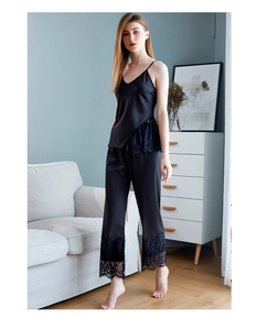 Detailed close-up of women's black satin pajama set with intricate floral lace trim accents