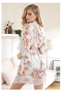Detail of floral white satin kimono robe featuring elegant wide eyelash lace trim