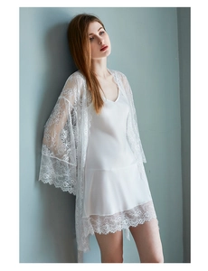Détail d'un ensemble pyjama en soie blanche avec manches et ourlet en dentelle florale