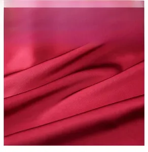Macro di tessuto satinato in seta ghiaccio rosso scuro con trama liscia e drappeggio lucido