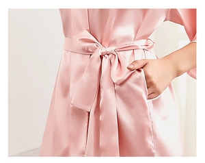 Detail of pink satin bridal robe featuring functional side pockets and adjustable waist tie