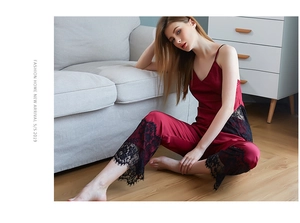 Detail of burgundy satin pajama set with intricate black lace trim and V-neckline finish