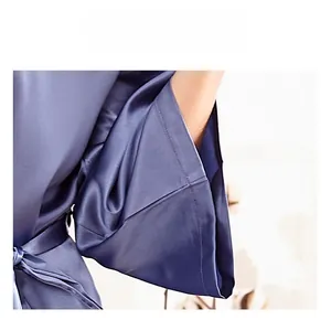 Detail of blue satin bridal robe featuring wide kimono sleeves and elegant stitching