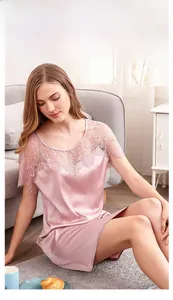 Détail d'une nuisette en soie rose avec patchwork de dentelle au décolleté et aux manches
