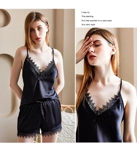 Detailed close-up of women's black ice silk pajamas with elegant lace trim and V-neckline