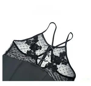 Dettaglio baby-doll nero in pizzo con ricamo floreale, rete a pois e fiocco decorativo