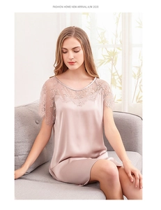 Détail d'une nuisette en satin champagne avec dentelle délicate sur la bordure de manche
