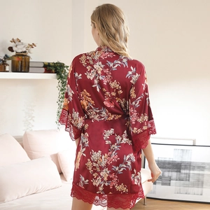 Elegant burgundy floral satin robe with lace trim shown from a back view in a cozy home setting