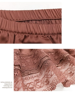 Detail eines dunkelbraunen Seidentops mit elastischem Bund und feiner floraler Spitzenkante