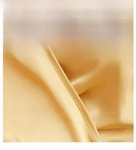 Close-up detail of champagne gold ice silk fabric with smooth satin finish and texture